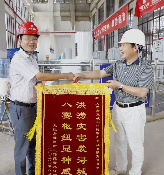 受九江市城区防汛指挥部、市水利局委托，九江市河湖局副局长王梅生向九江三峡水环境公司赠送锦旗。  摄影：陈洁